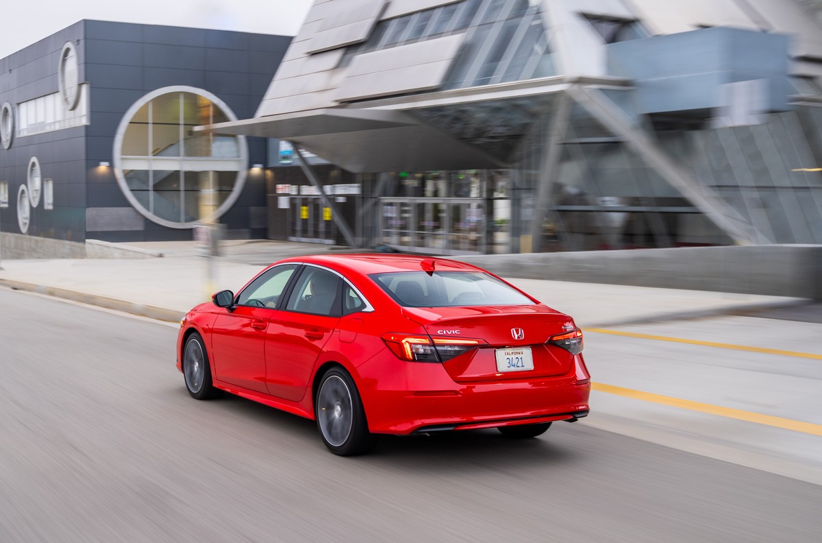 Red 2022 Honda Civic sedan driving away in a city