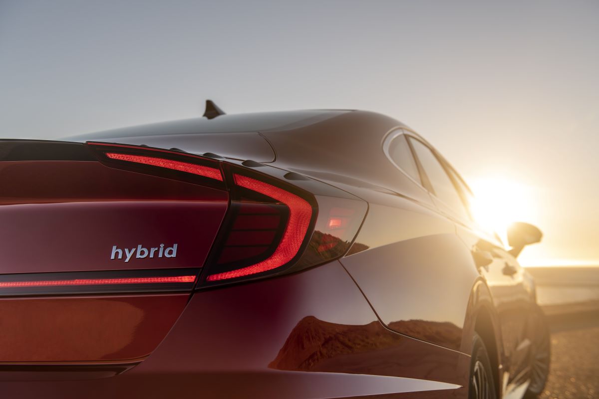 Close up view of the rear of a red 2022 Hyundai Sonata Hybrid fuel-efficient midsize sedan with the hybrid badge featured prominently