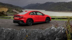 Red 2022 Subaru WRX parked on the side of the road on a dark, foggy day. The 2022 WRX's specs are similar to last year's.