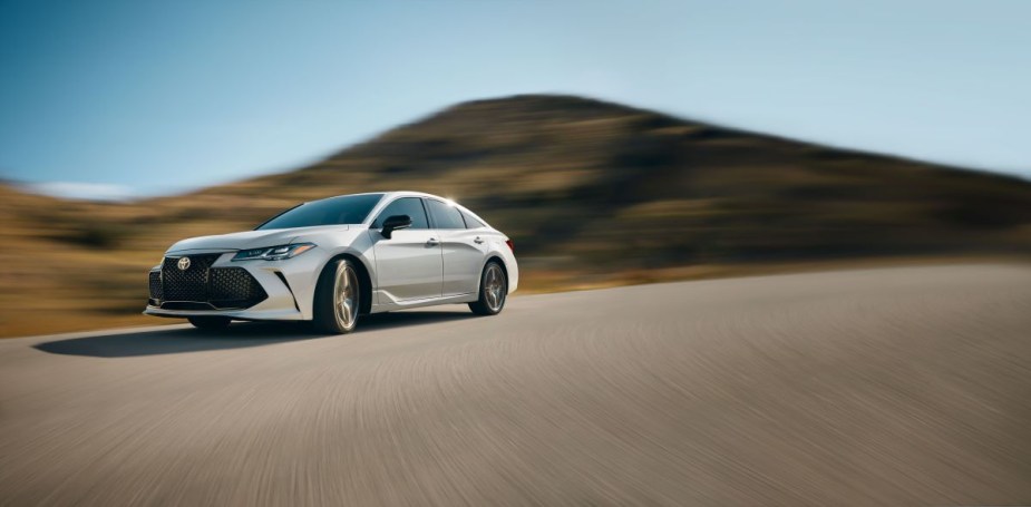 White Toyota Avalon Touring, a V6 sedan, drifting around a curve