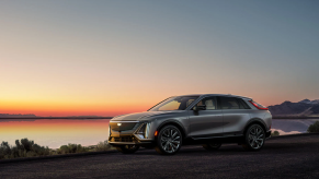 A gray 2023 Cadillac Lyriq luxury electric SUV model parked near a beach during sunset