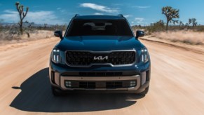 A green 2023 Kia Telluride is driving off-road.