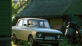 A classic beige Moskvich car in a Russian farmyard