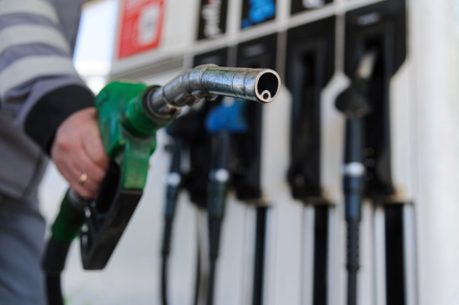 A green gas pump nozzle at a gas station.