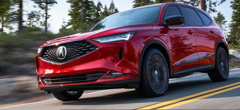 A red 2022 Acura MDX in a woods. 