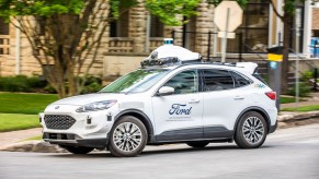 An Argo AI full self-driving taxi and delivery Ford Escape on public roads in Austin, Texas side profile