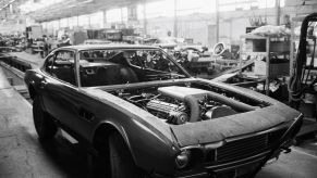 A removed hood on an Aston Martin car with engine, powertrain, and fuel injectors