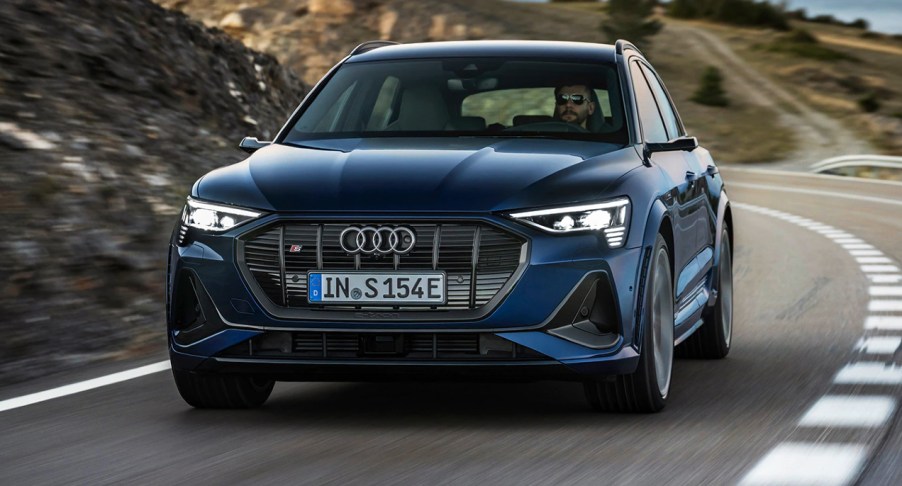 A blue 2022 Audi e-tron S is driving on the road.