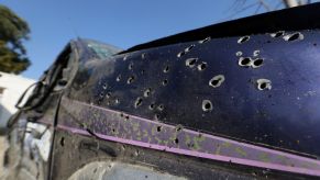 Some may seek protection from bullet holes behind a car like this one that exhibits bullet holes.