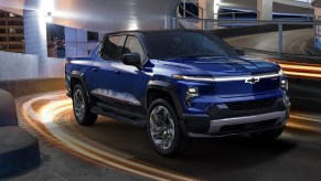 A blue 2024 Chevy Silverado EV RST blue electric pickup truck is driving.