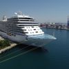 A large cruise ship on the water at dock.