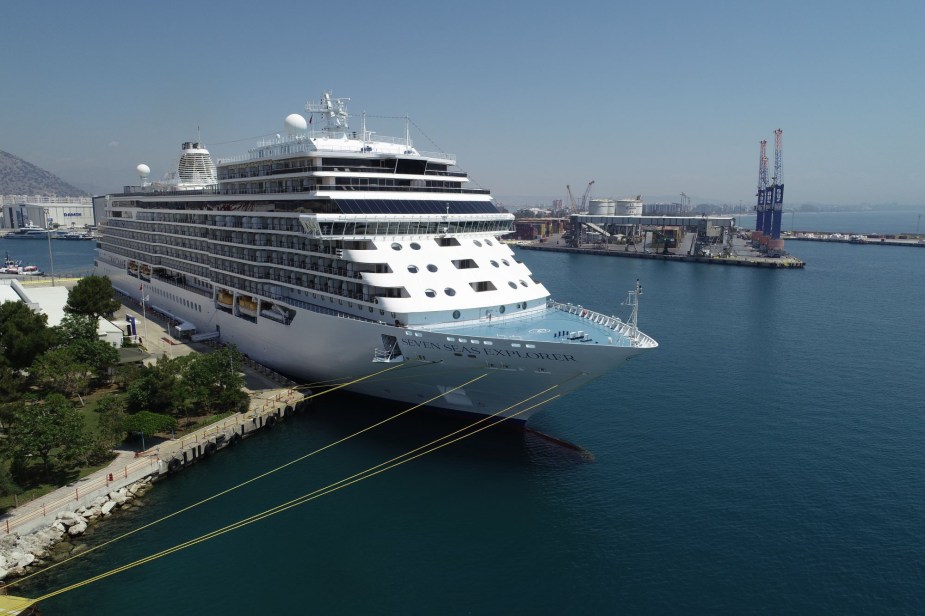 A large cruise ship on the water at dock. 