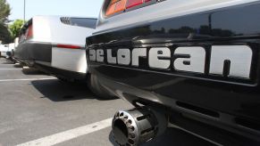 Delorean written on the bumper of a classic grey Delorean car.