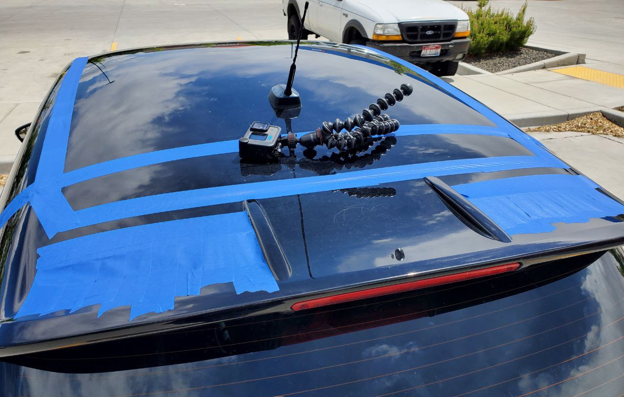 Rear spoiler of tape covered 2016 Ford Fiesta ST in parking lot before road trip