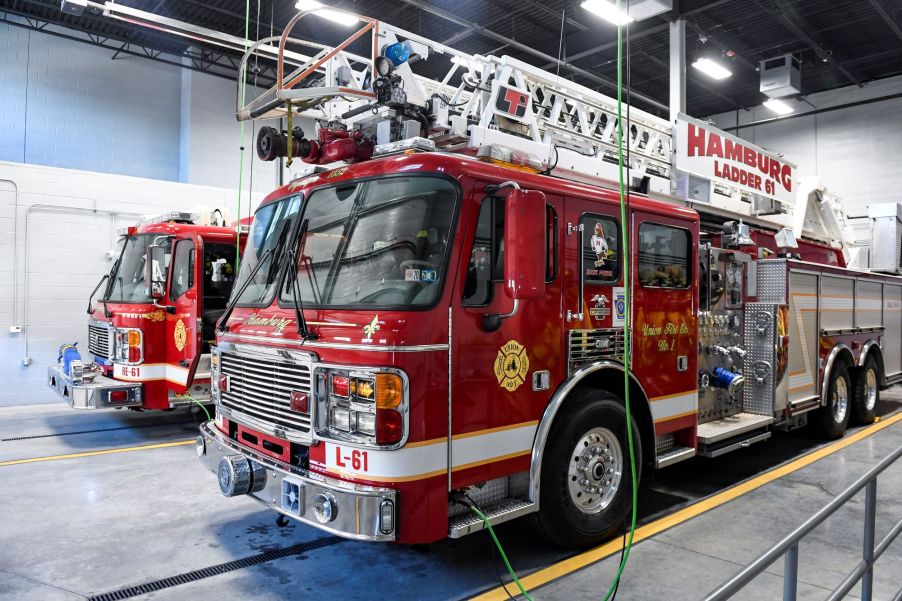 Two red fire trucks parked inside.