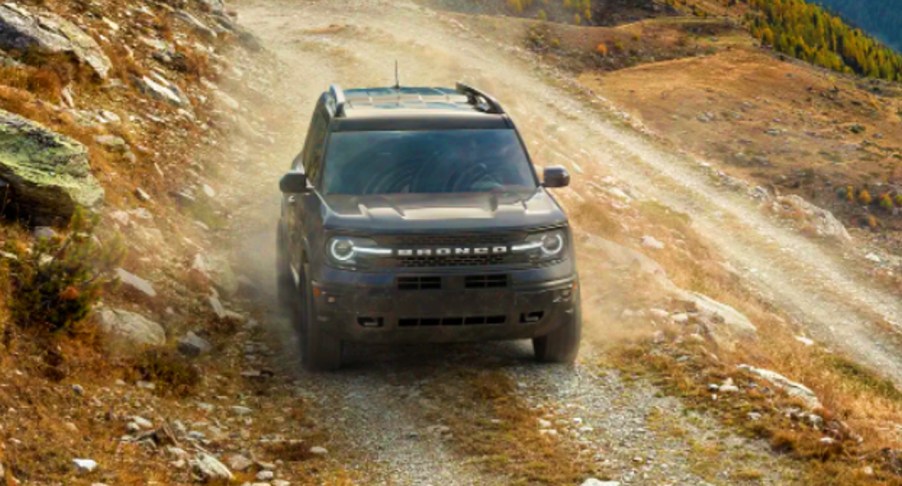 A blue 2022 Ford Bronco Sport small SUV is driving off-road.