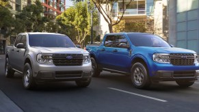 Two Ford Maverick small pickup trucks are driving on the road.