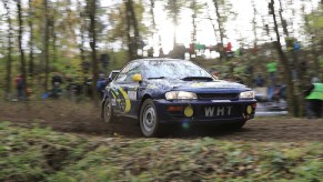 GC8 Subaru Impreza STI 22B Style Restomod Rally Car Sliding Sideways around a muddy rally stage corner