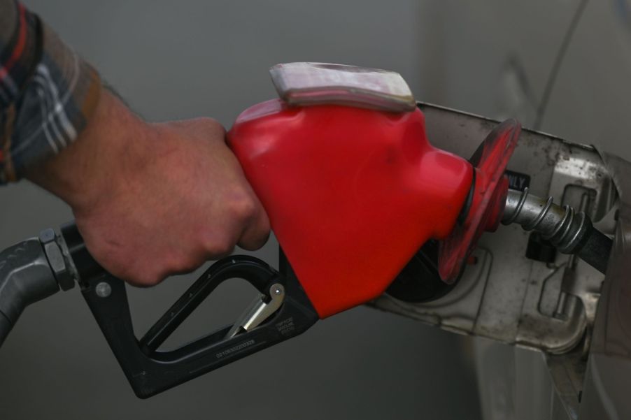 A gas pump nozzle in a car with possible additives to improve gas mileage.