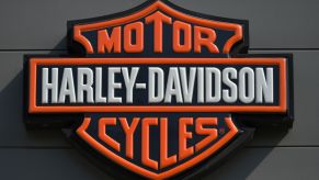 A black, orange, and white Harley-Davidson logo, creator of the 2022 Harley-Davidson Nightster.