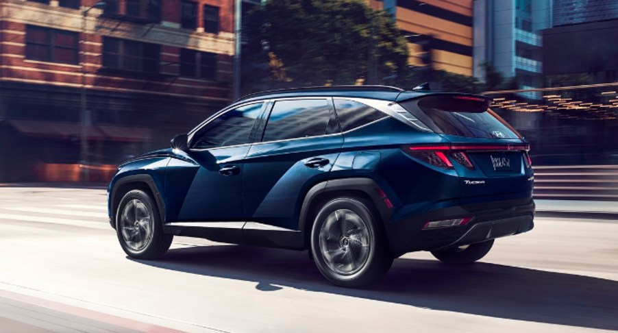 A blue 2022 Hyundai Tucson Hybrid SUV is driving.