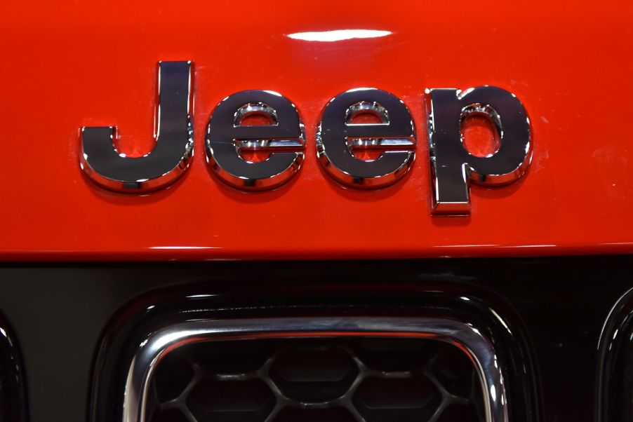 A chrome Jeep logo, maker of the 2022 Jeep Compass, on a red Jeep.