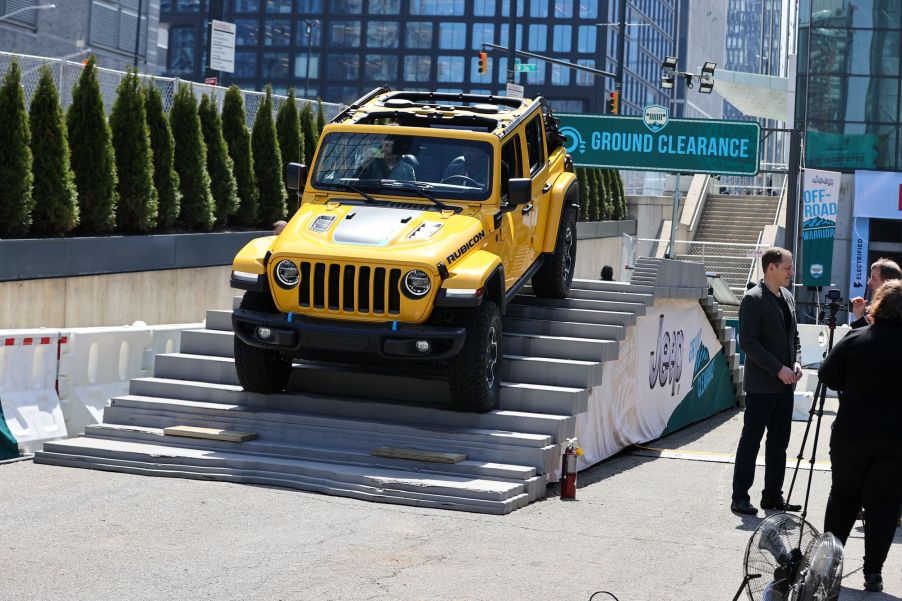 A yellow Jeep Wrangler coming down an incline.