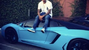 Chris Brown sitting atop a custom painted Miami Blue Lamborghini Aventador that recently sold on Cars and Bids