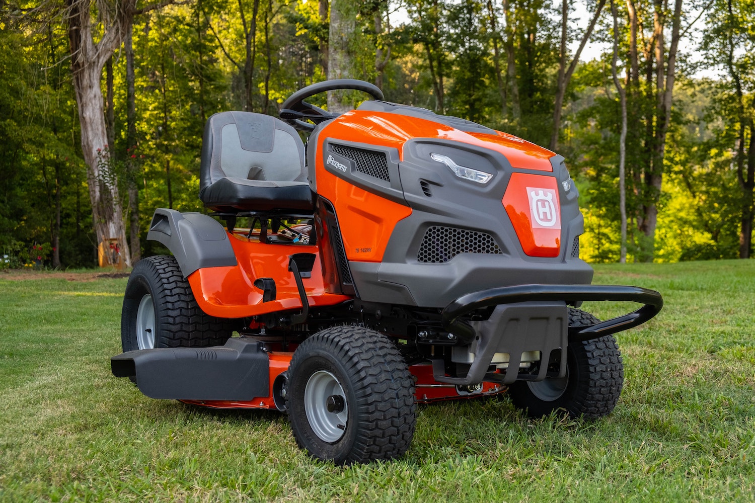 Orange lawn tractor parked on a lawn.