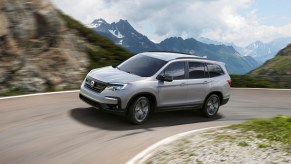 Lunar Silver Metallic 2022 Honda Pilot driving on a mountain road