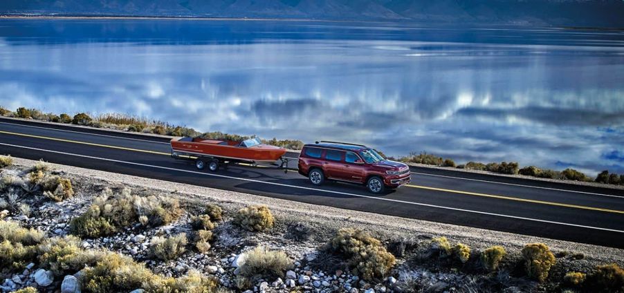 Maroon 2022 Jeep Wagoneer, the only SUV that can tow 10,000 pounds, towing a boat