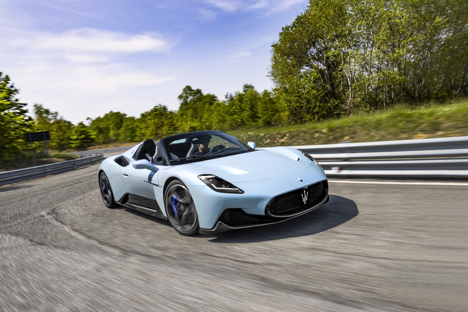 Sky blue Maserati Mc20 Cielo convertible driving down racetrack