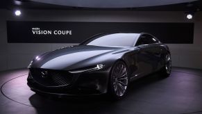 A gun metal gray Mazda Vision concept car in an indoor environment.