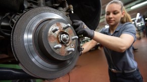 Mechanic working on the brake system of a car, bleeding brakes via caliper bleeder screw