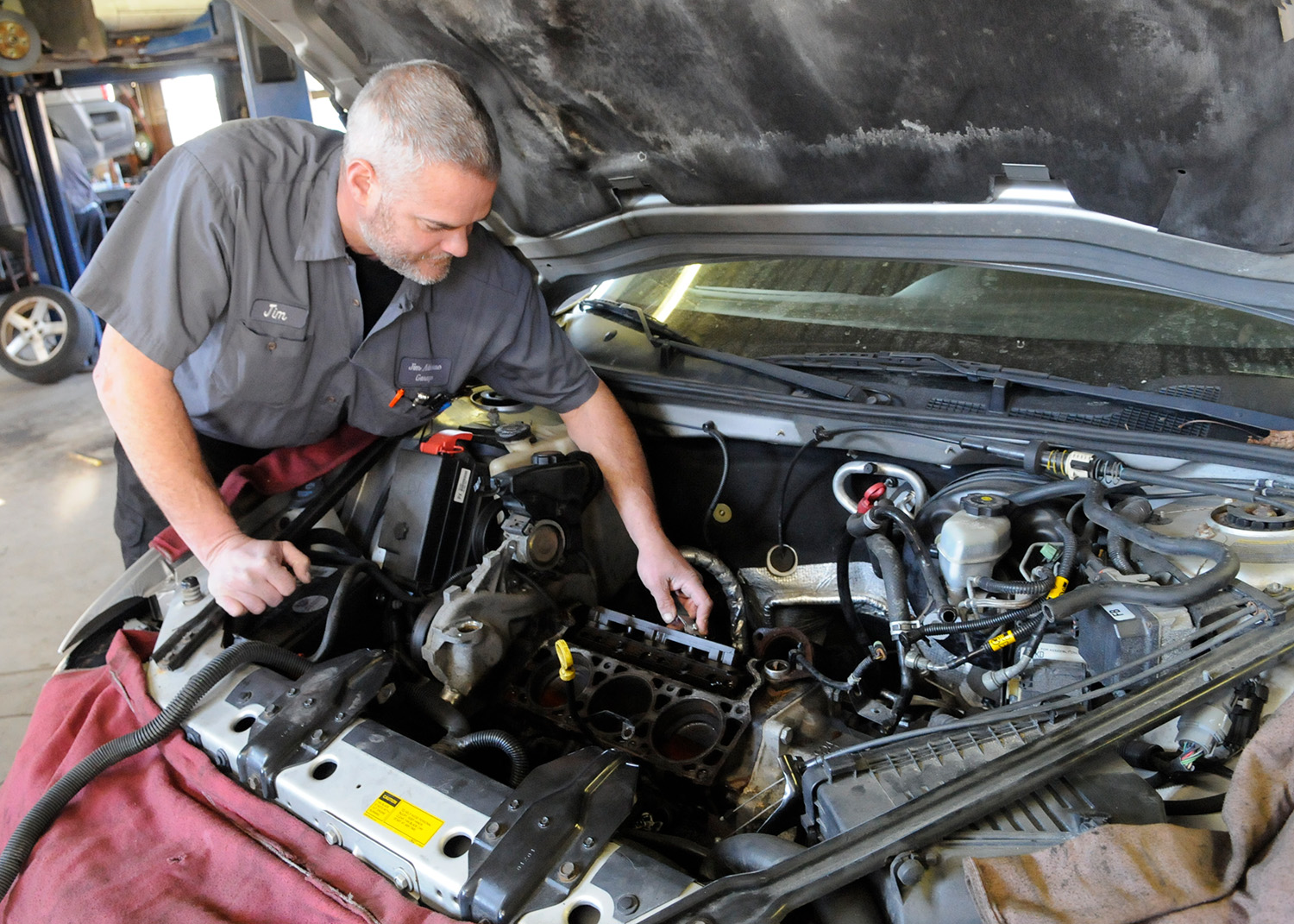 Mechanic repairing a head gasket on a three-cylinder engine