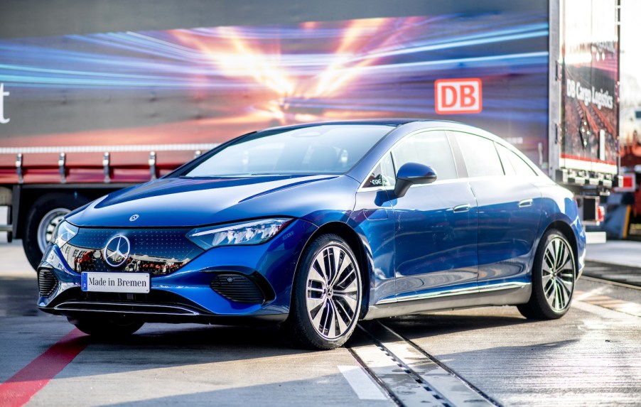 A blue electric Mercedes sedan parked outdoors on a sunny day.