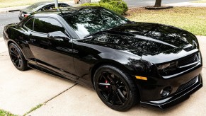 A black modified 2010 Chevrolet Camaro SS on a driveway