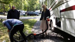 A person learning how to hook up an RV, which is important traveling with your RV.