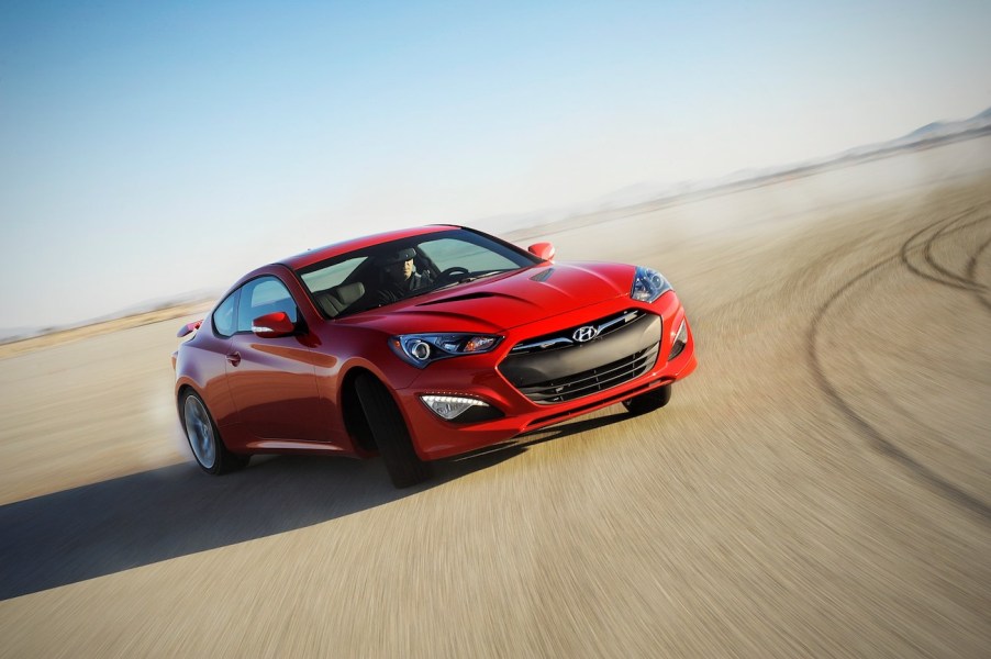 A red 2016 Genesis Coupe drifting on a track