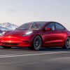 Red 2022 Tesla Model 3, a car that's loved and hated, with mountains in the background