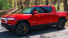 A red 2022 Rivian R1T Launch Edition electric pickup truck is pared on a sunny day.