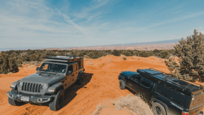 Rossmonster campers parked in the desert. One is mounted to a Jeep Gladiator and the other on a Toyota Tacoma