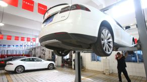 Tesla automotive car service being performed by a maintenance technician in Ningo, Zhejiang, China