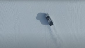 Pickup truck driving through a snowy field.