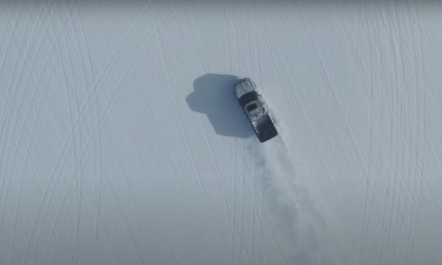 Pickup truck driving through a snowy field.