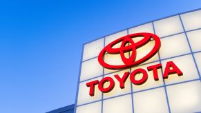 A red Toyota logo with Toyota written under it on a white background with a clear sky in the background.