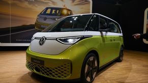 A green and white Volkswagen ID. Buzz inside on light colored wood floors.