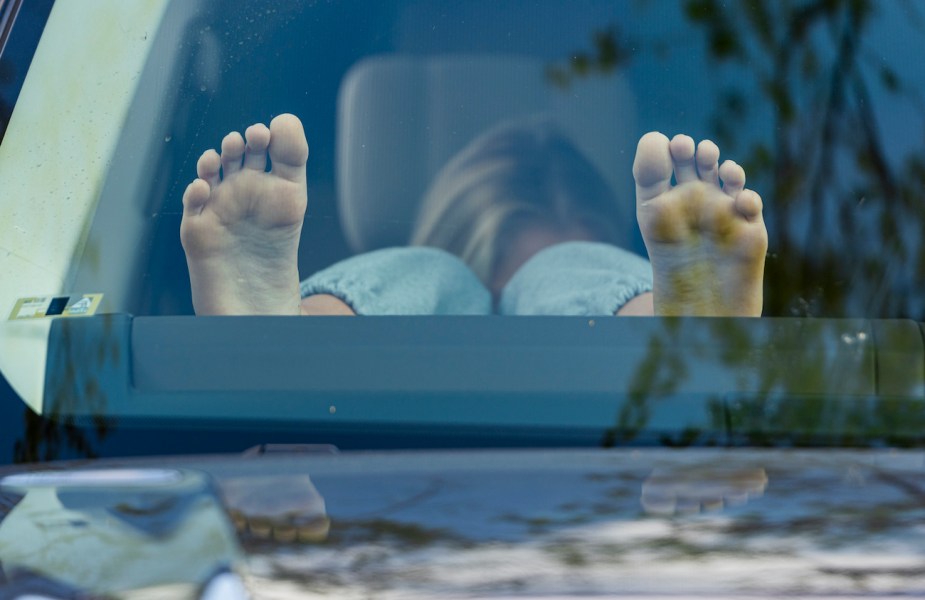 Lola Gehl of Newport Beach props her feet up on the dashboard.