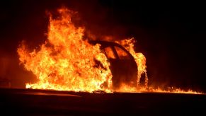 A car completely engulfed in flames. Automotive fire extinguishers can only handle small fires.