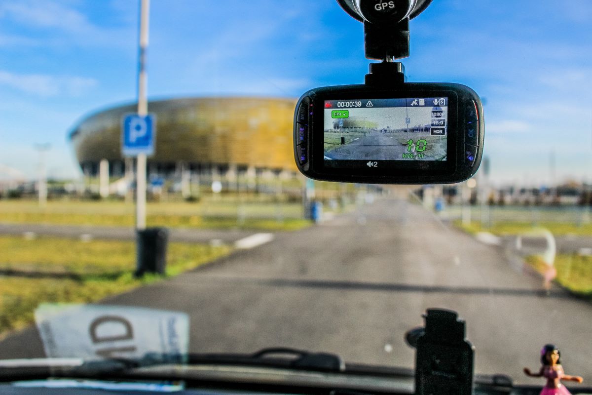 Dash cam installed on a front windshield of a car looking out onto the road ahead. In-car cameras have a lot of benefits